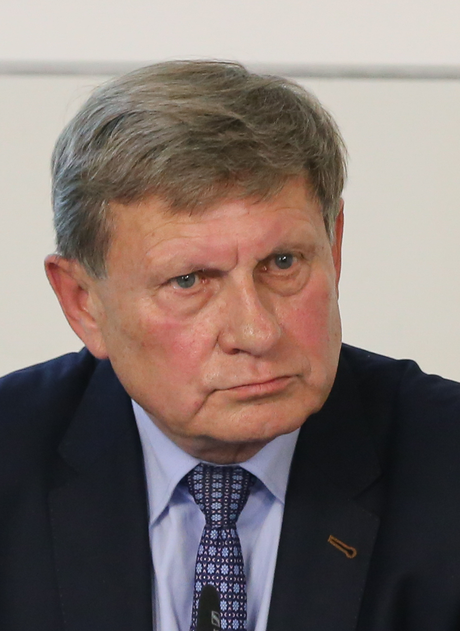 Портрет пожилого мужчины в очках и деловом костюме